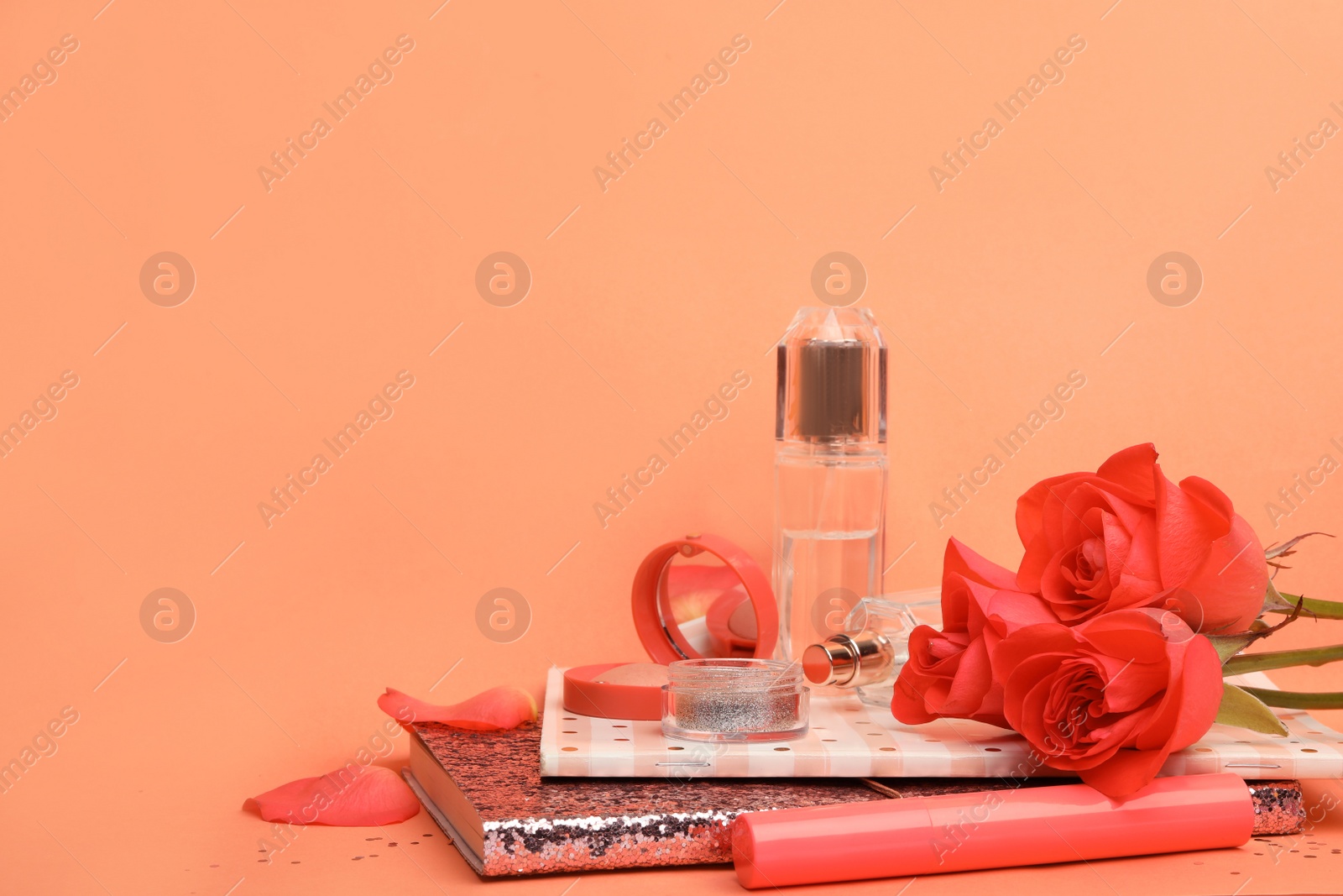 Photo of Beautiful composition with beauty accessories, notebooks and coral flowers on color background. Space for text