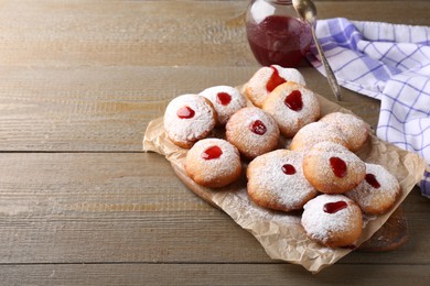 Hanukkah donuts with jelly and powdered sugar on wooden table, space for text