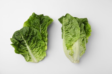 Photo of Fresh green romaine lettuce and leaves isolated on white, top view