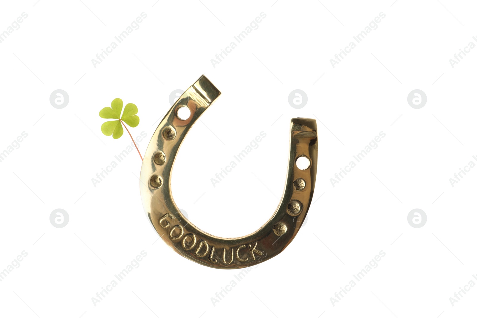 Photo of Golden horseshoe with phrase GOOD LUCK and clover on white background. St. Patrick's Day celebration