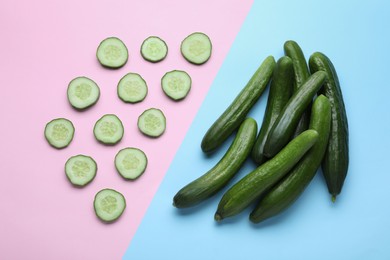 Whole and cut fresh ripe cucumbers on color background, flat lay