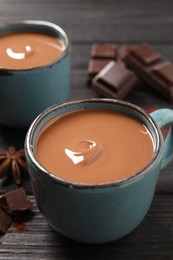 Photo of Yummy hot chocolate on black wooden table