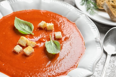 Photo of Plate with fresh homemade tomato soup on table, closeup