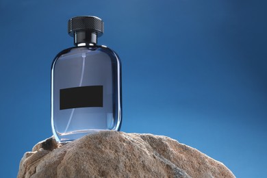 Photo of Stylish presentation of luxury men`s perfume on stone against light blue background. Space for text