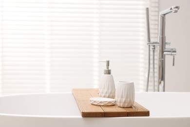 Set of bath accessories on tub in bathroom, space for text