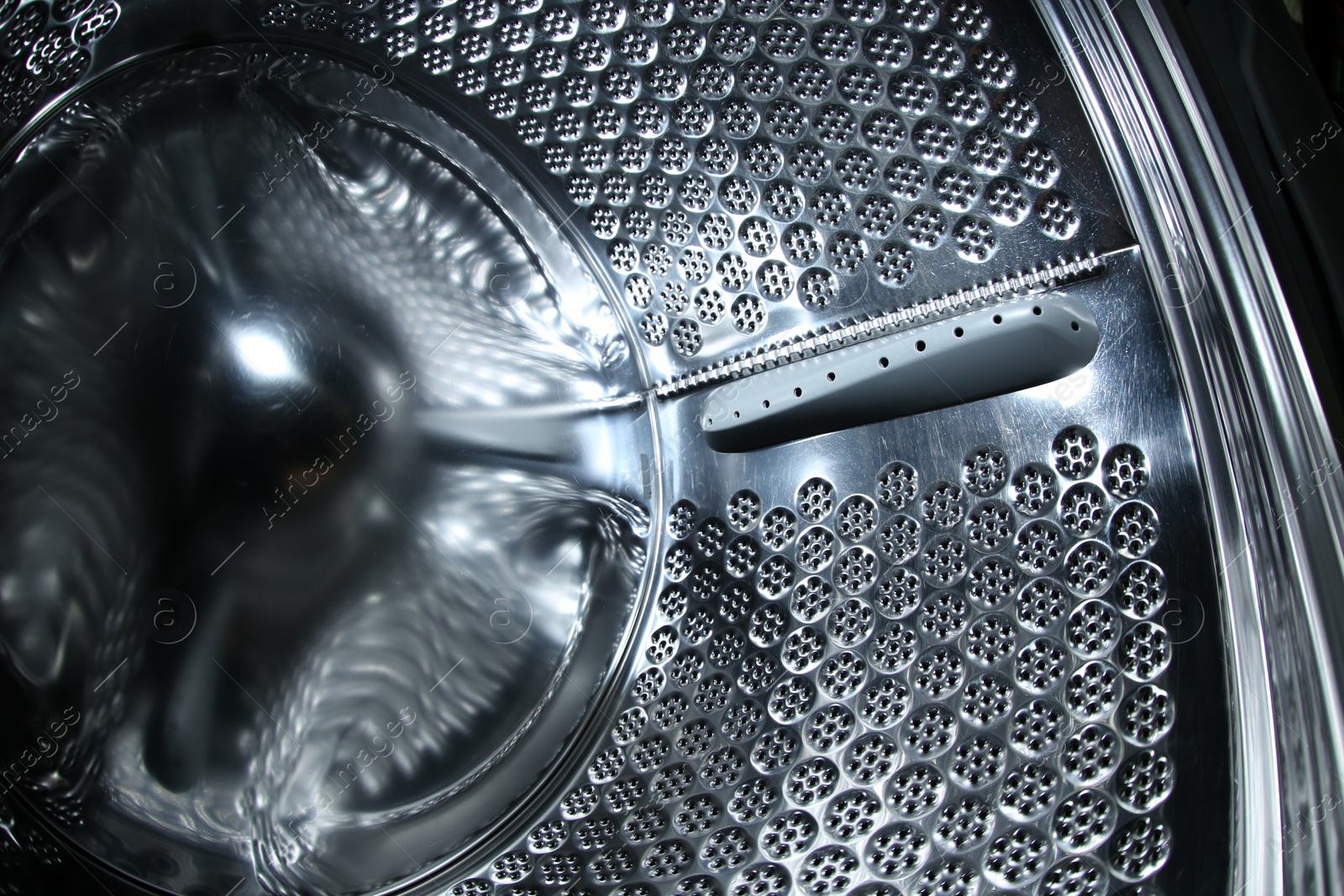 Photo of Empty washing machine drum, closeup view. Laundry day