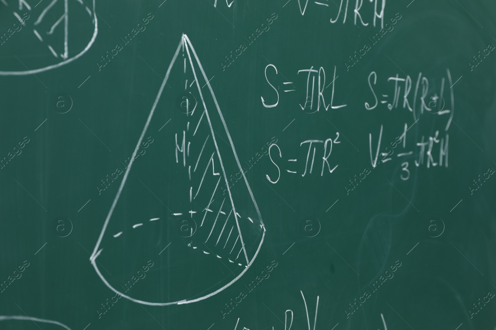 Photo of Different math formulas written with chalk on green board