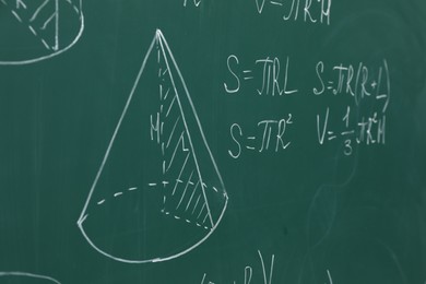 Photo of Different math formulas written with chalk on green board