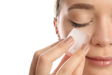 Young woman with ice cube on white background, closeup. Skin care