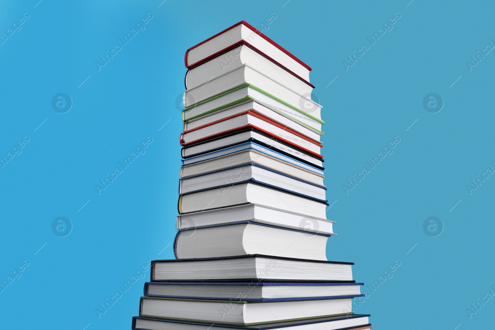 Photo of Stack of hardcover books on light blue background