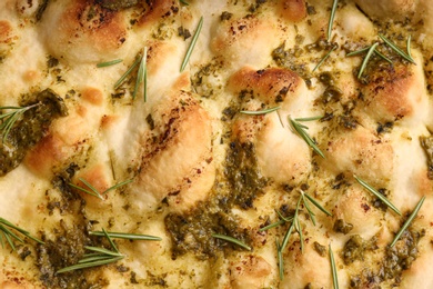 Photo of Traditional Italian focaccia bread with guacamole and rosemary as background, closeup