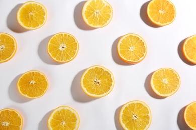 Slices of delicious oranges on white background, flat lay