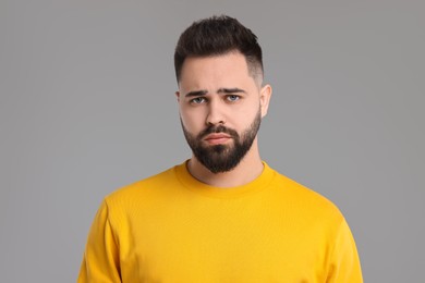 Photo of Portrait of sad man on light grey background