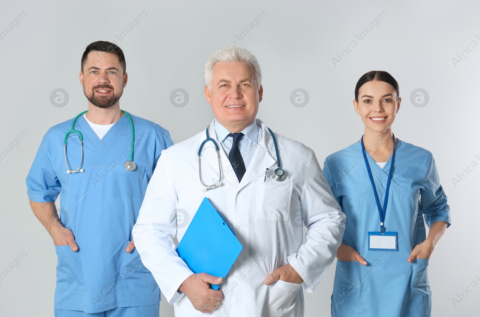 Photo of Group of doctors against light background. Medical service