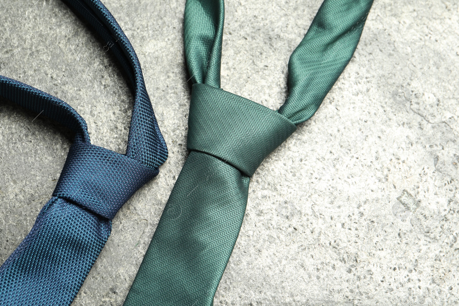 Photo of Two neckties on grey textured background, top view. Space for text