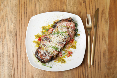 Photo of Delicious roasted meat served on wooden table, flat lay