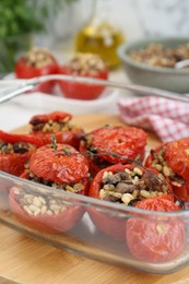 Photo of Delicious stuffed tomatoes with minced beef, bulgur and mushrooms in glass baking dish, closeup