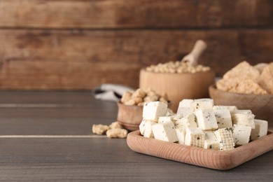 Photo of Natural tofu and other soy products on wooden table, space for text