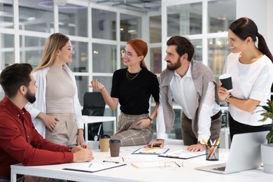 Photo of Team of employees working together in office