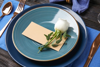 Elegant festive table setting with blank card on black wooden background
