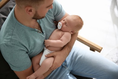 Photo of Father with his newborn son at home, above view