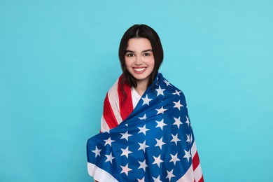 Photo of 4th of July - Independence Day of USA. Happy girl with American flag on light blue background