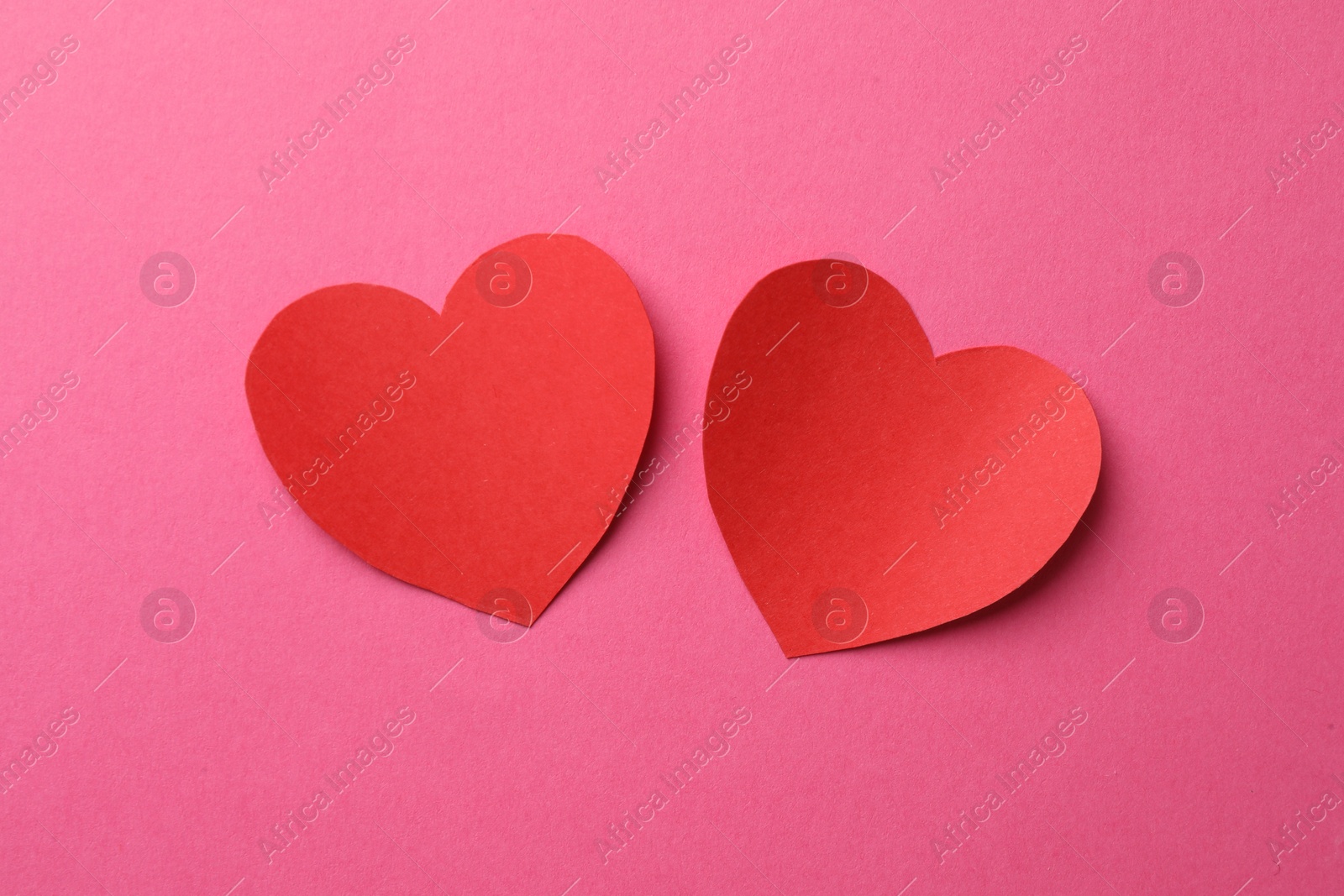 Photo of Red paper hearts on pink background, flat lay