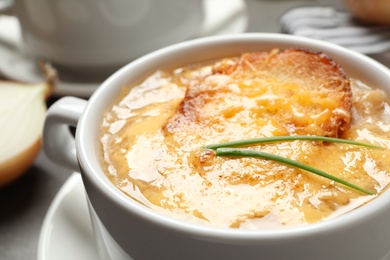 Photo of Tasty homemade french onion soup on table, closeup