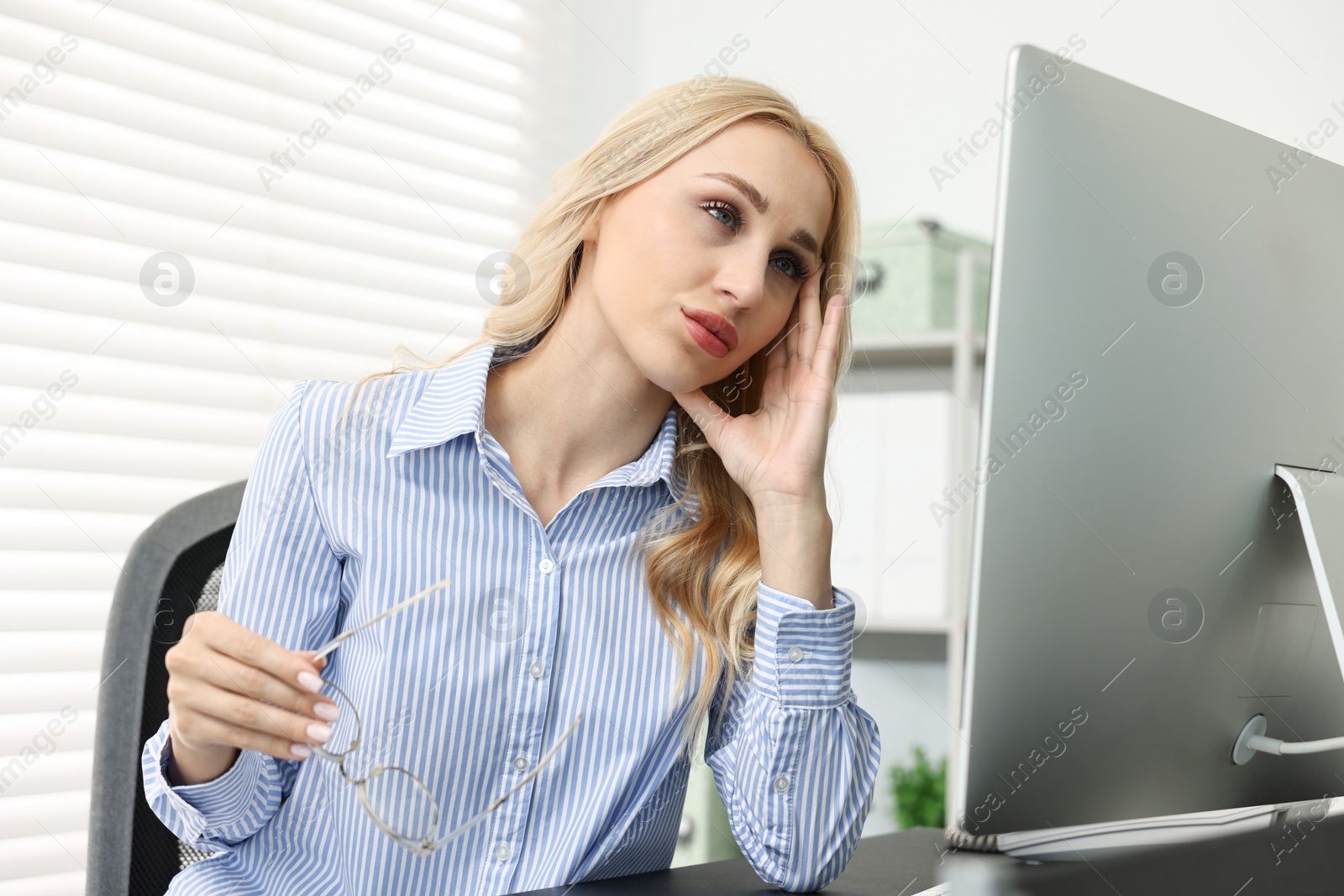 Photo of Overwhelmed woman with glasses at table in office