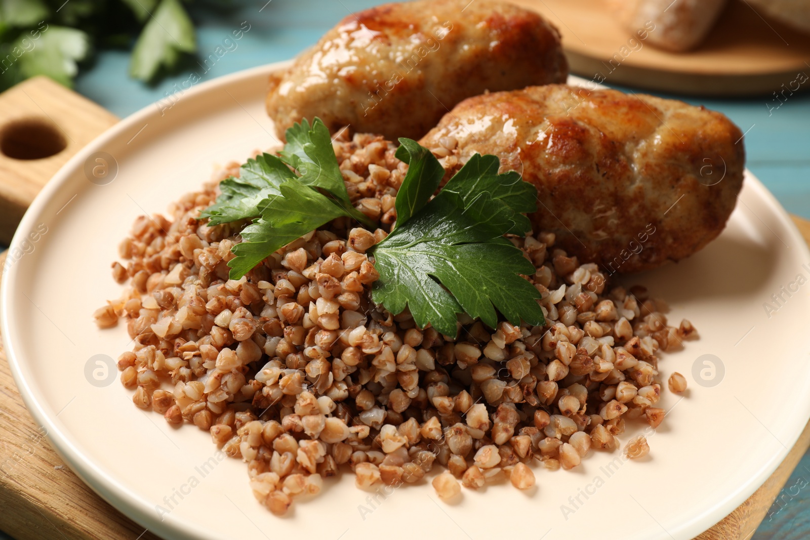 Photo of Tasty buckwheat with fresh parsley and cutlets on table, closeup