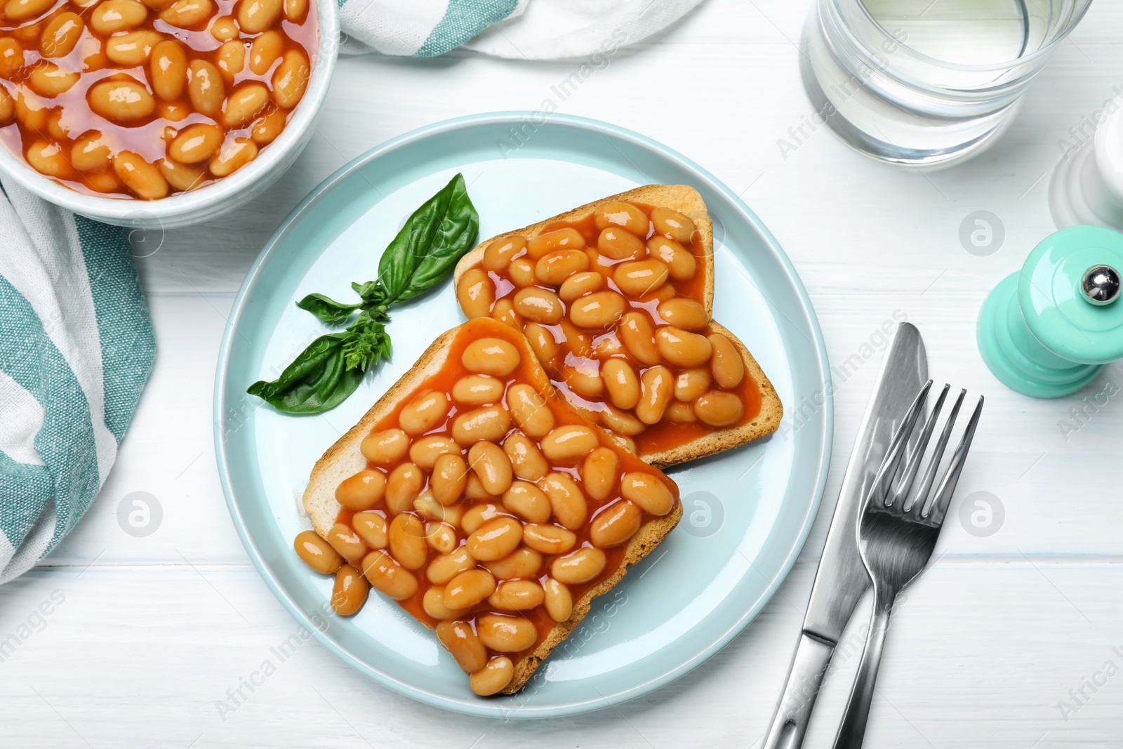 Photo of Toasts with delicious canned beans on white wooden table, flat lay