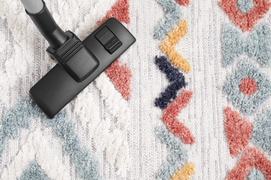 Photo of Hoovering carpet with modern vacuum cleaner indoors, top view. Space for text