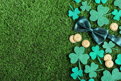 Photo of Flat lay composition with clover leaves on green grass, space for text. St. Patrick's Day celebration