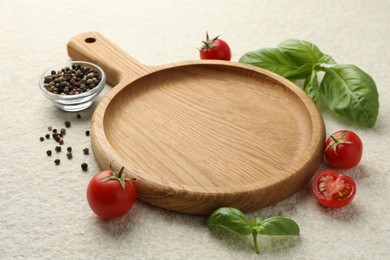 Photo of Cutting board, basil, spices and tomatoes on white textured table. Space for text