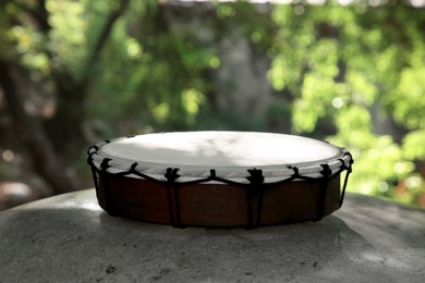 Photo of Modern drum on stone outdoors. Percussion musical instrument
