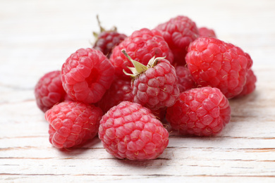 Photo of Delicious fresh ripe raspberries on white wooden table, closeup