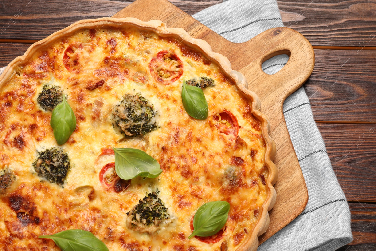 Photo of Delicious homemade vegetable quiche on wooden table, top view