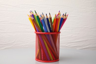 Photo of Many colorful pencils in holder on white background