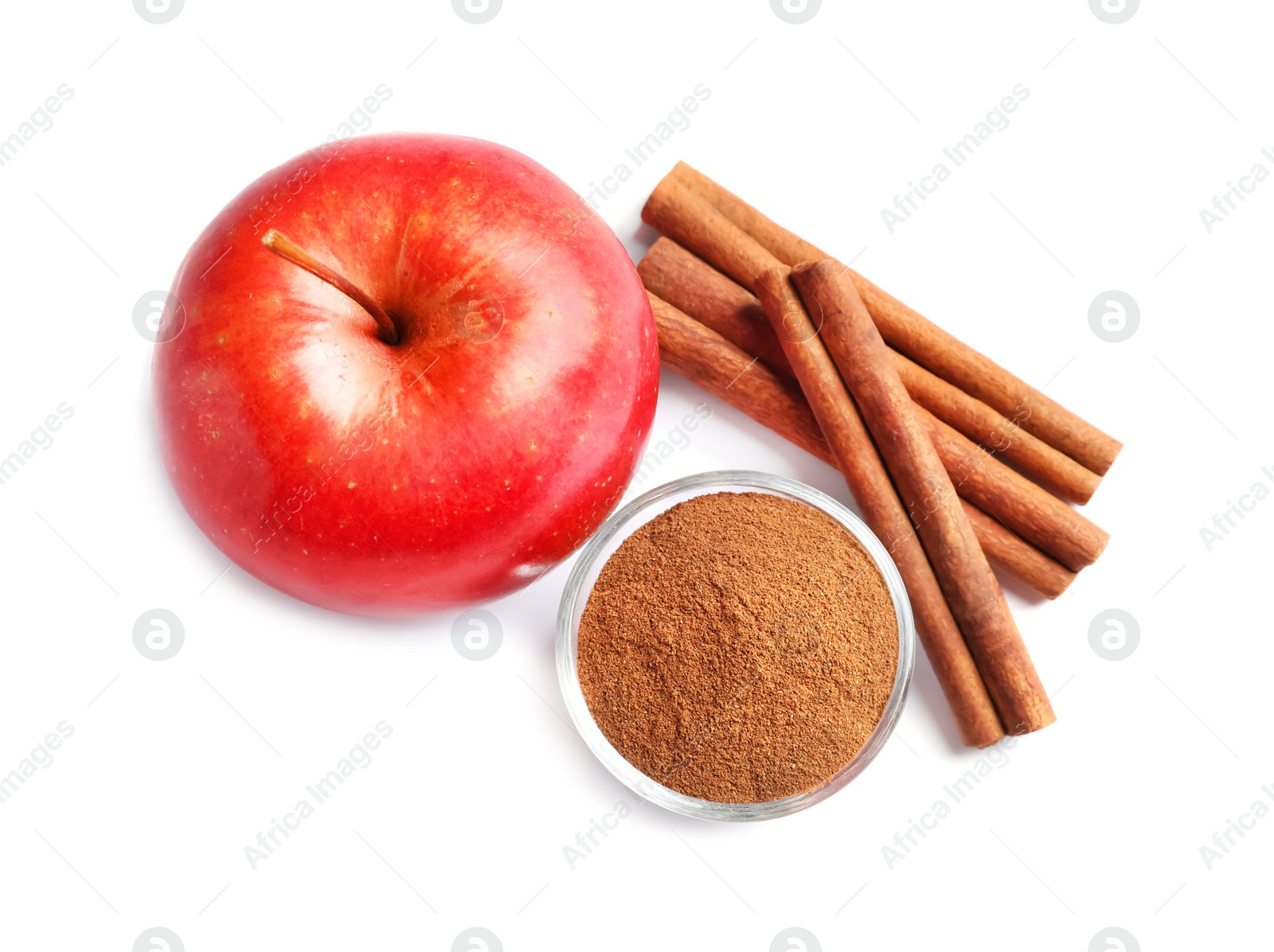 Photo of Fresh apple with cinnamon sticks and powder on white background