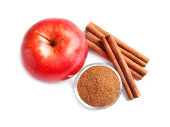 Photo of Fresh apple with cinnamon sticks and powder on white background