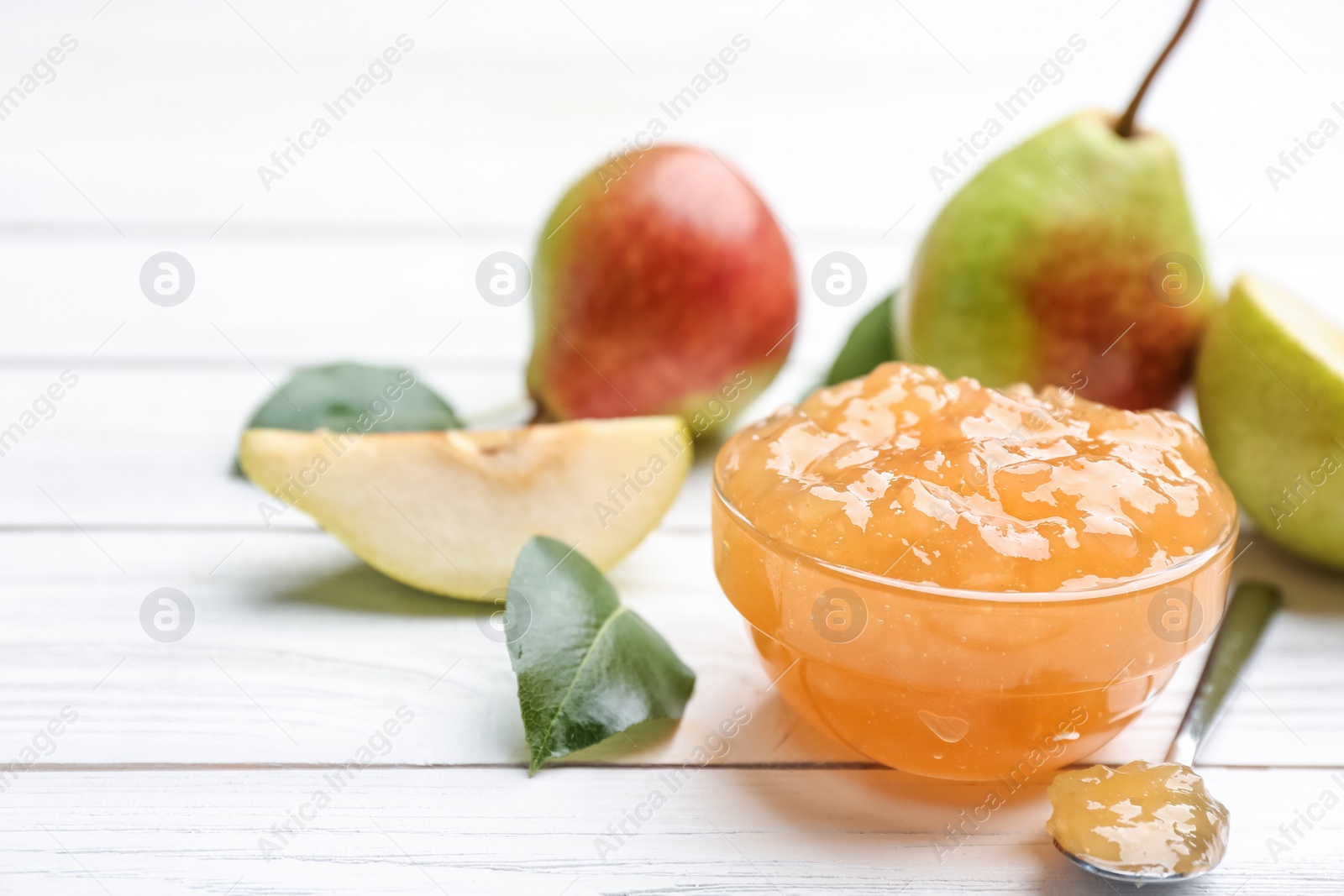 Photo of Delicious pear jam and fresh fruits on white wooden table, closeup. Space for text