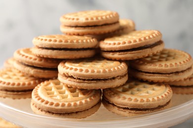 Photo of Tasty sandwich cookies with cream on tray, closeup