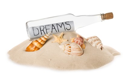 Photo of Corked glass bottle with Dreams note and seashells on sand against white background
