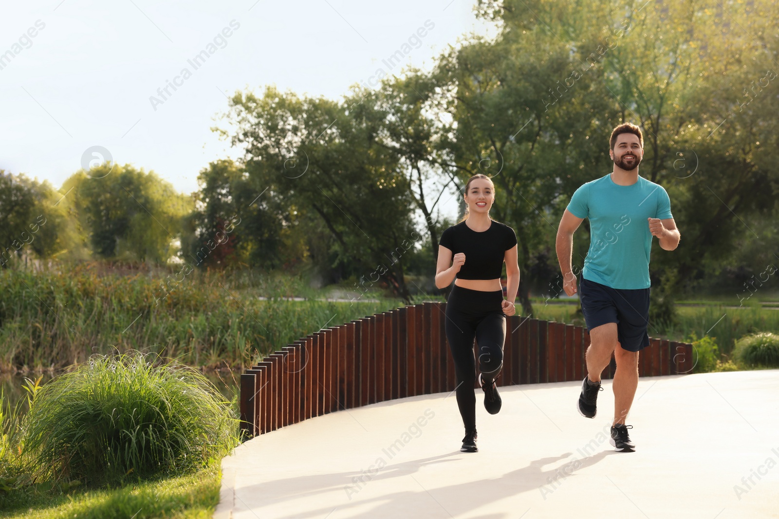 Photo of Healthy lifestyle. Happy couple running outdoors, space for text