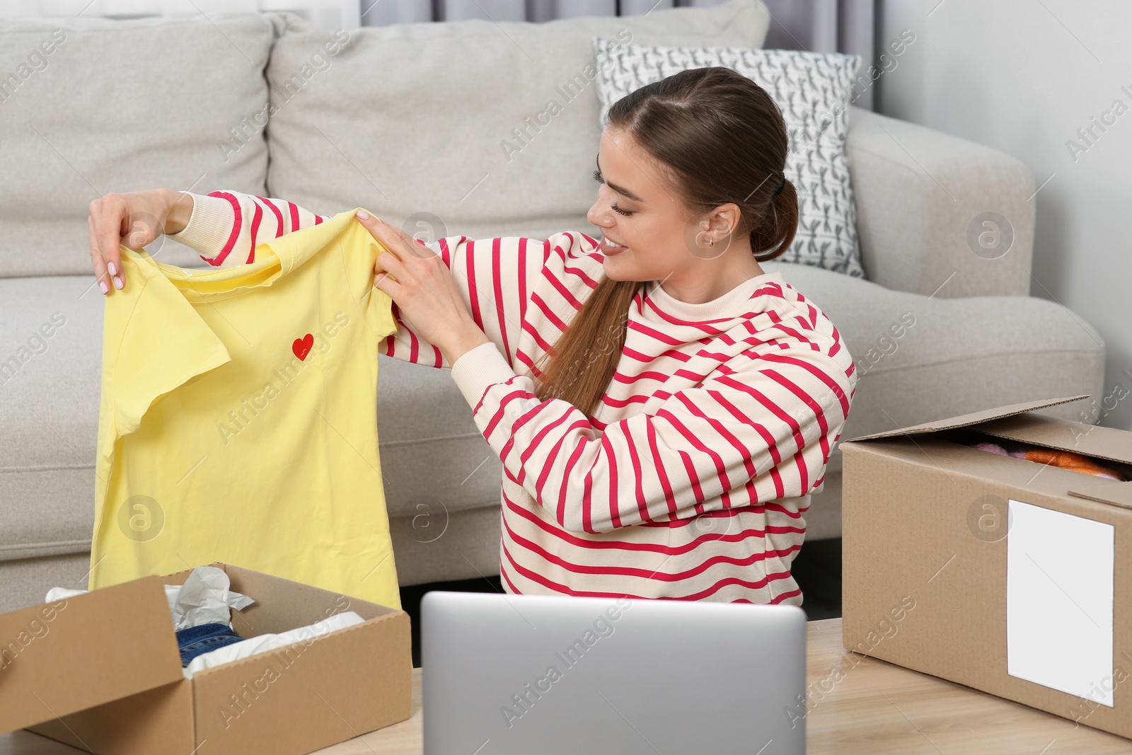 Photo of Happy woman unpacking parcels at home. Online store