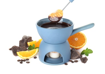 Fondue pot with chocolate and fruits on white background