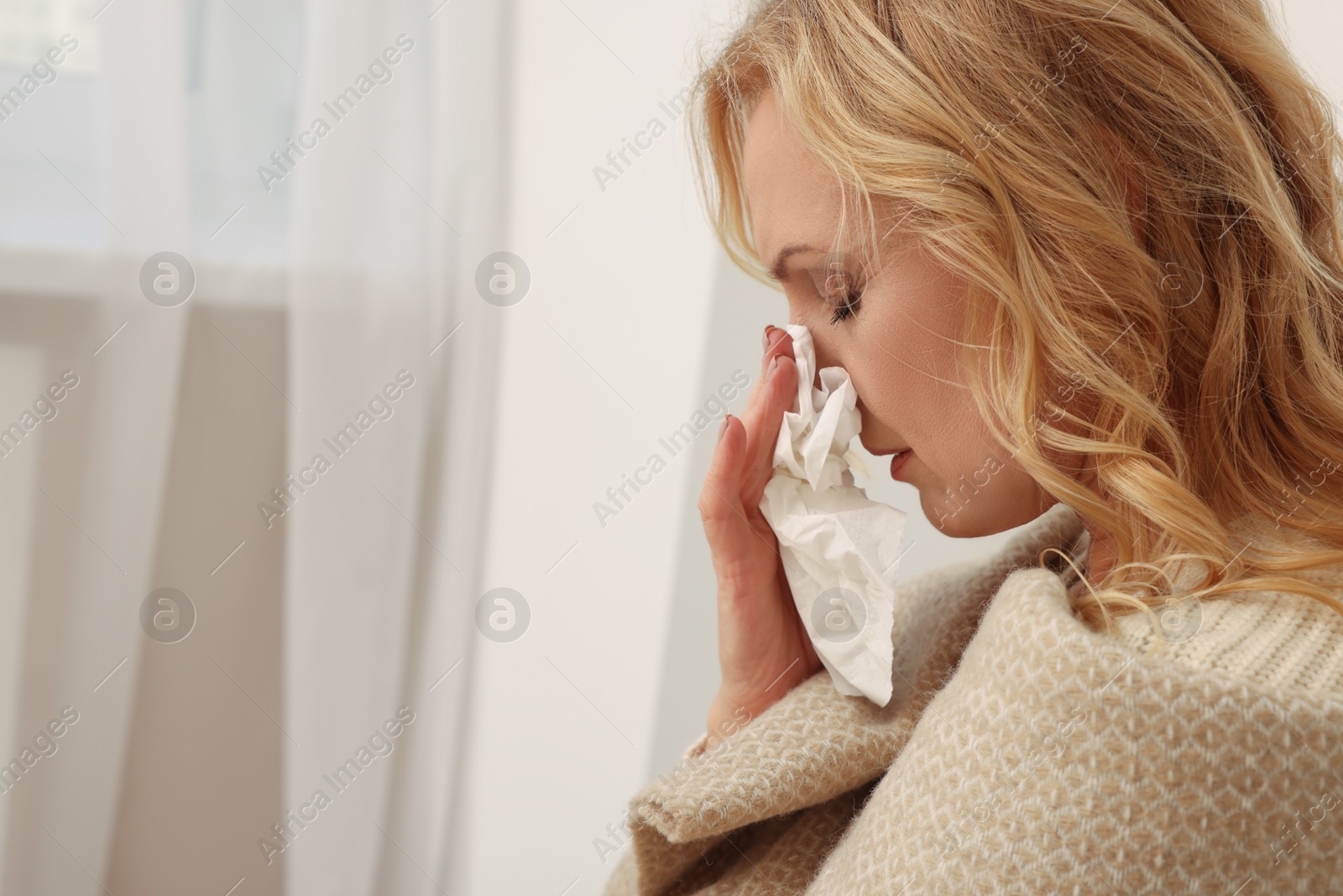 Photo of Upset middle aged woman with paper tissue at home, space for text. Loneliness concept