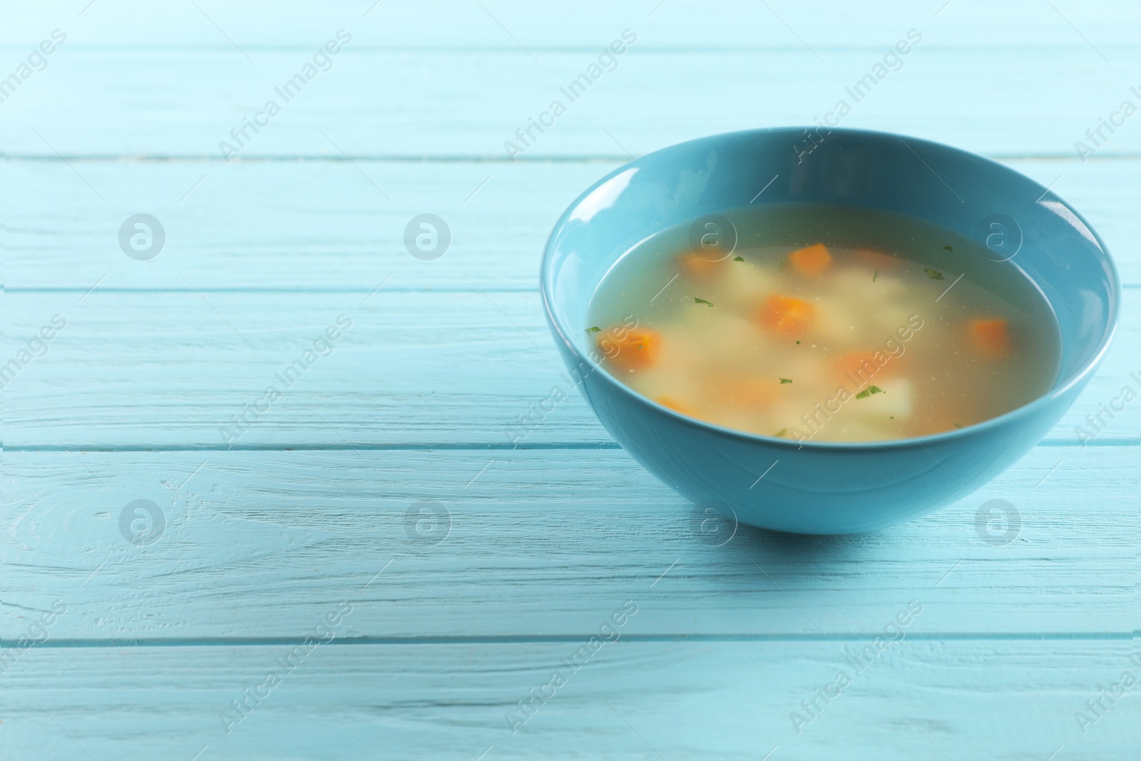 Photo of Bowl of fresh homemade soup to cure flu and space for text on wooden background