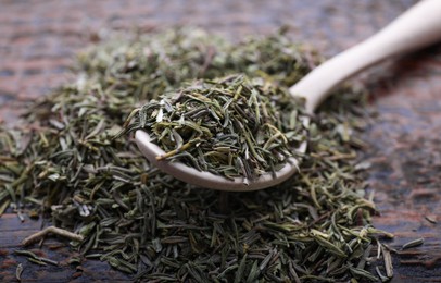 Spoon with dried thyme on wooden table, closeup