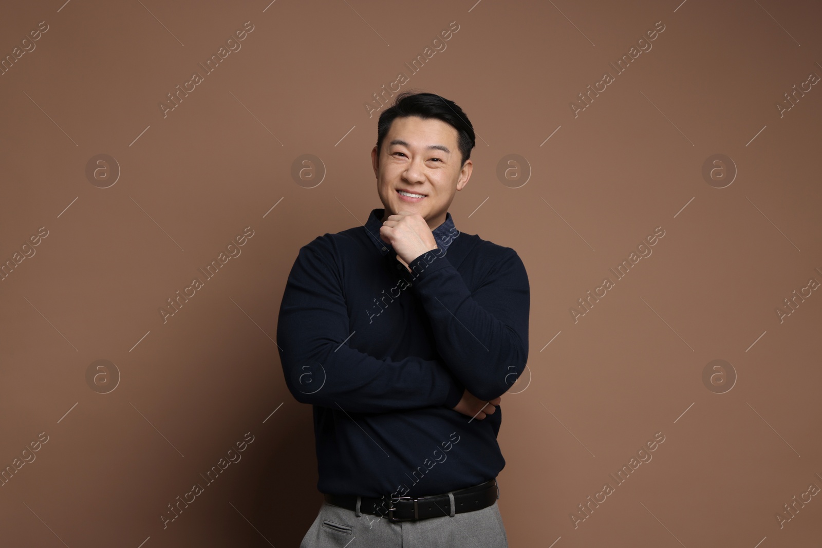 Photo of Portrait of happy man on brown background